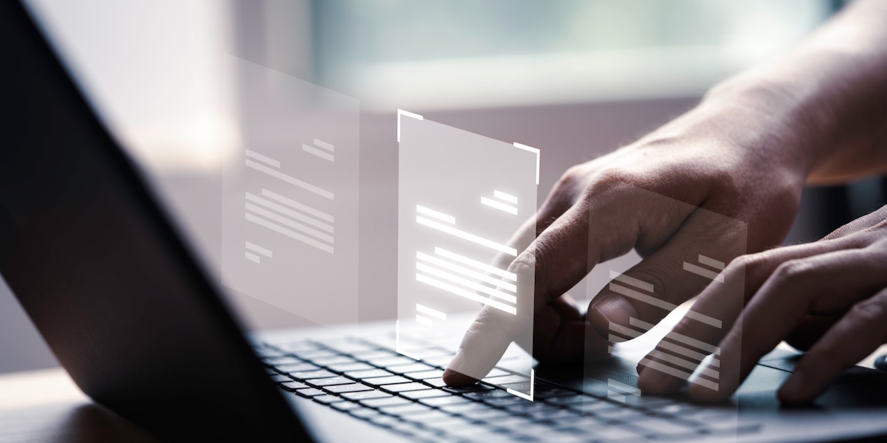 Hand using laptop computer with virtual screen and document for online approve paperless quality assurance and ERP management concept.