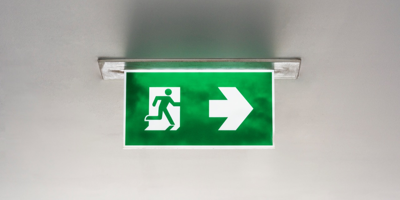 Green emergency exit sign on the ceiling
