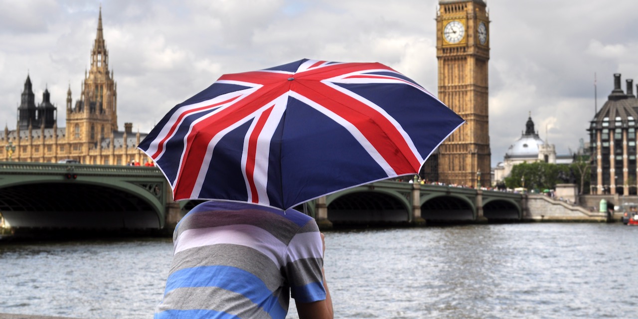 Big Ben and tourist with British flag umbrella in London