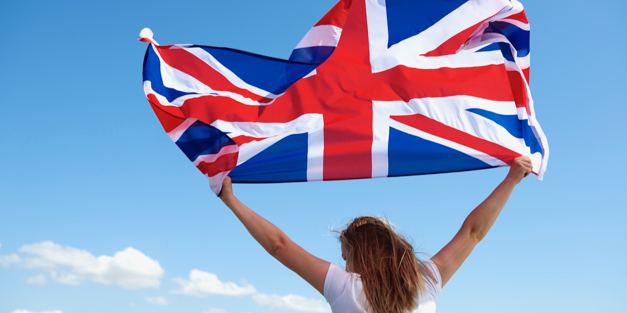 Rear view of young woman waving the British flag
