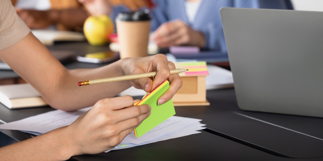 giovane-donna-che-scrive-informazioni-su-note-adesive-durante-la-sessione-di-studio