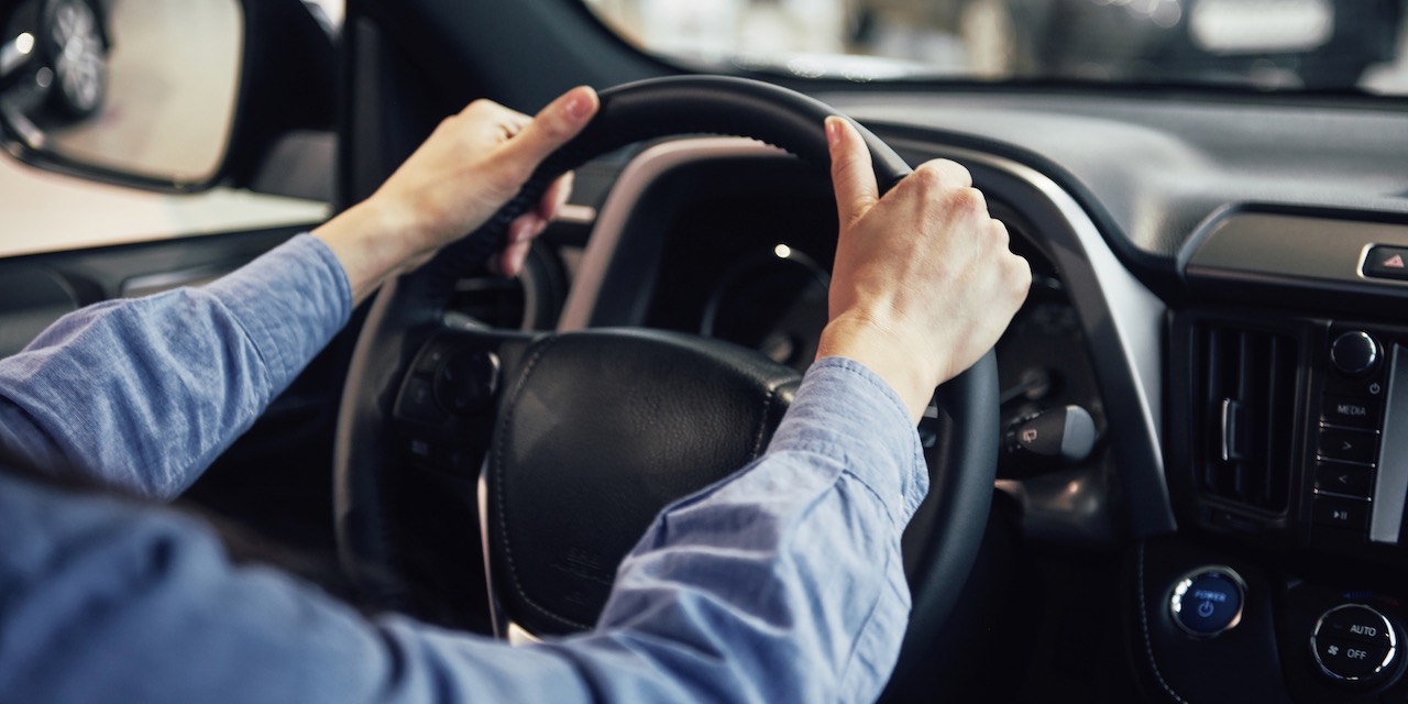auto business, car sale, consumerism and people concept – happy woman taking car key from dealer in auto show or salon