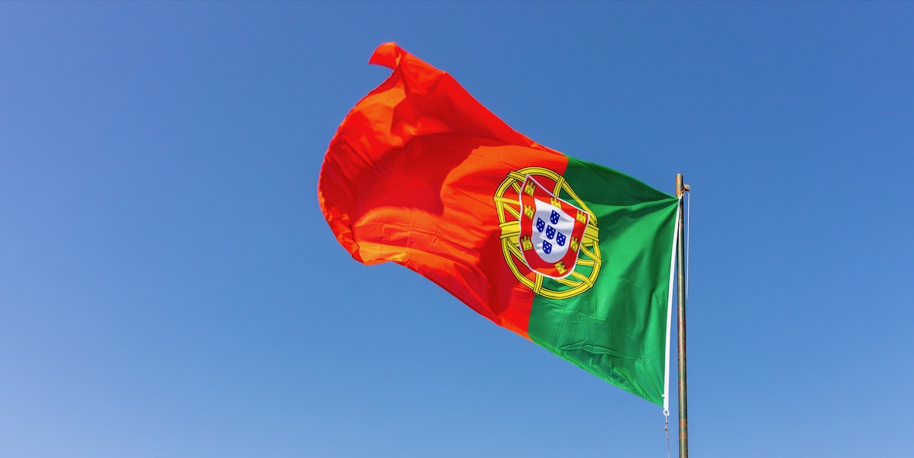 Beautiful shot of the Portuguese flag waving in the calm bright sky