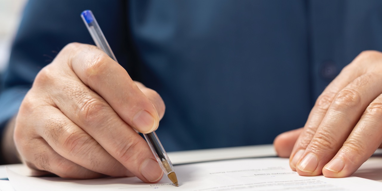 Senior man signing the financial contract with advisor expert