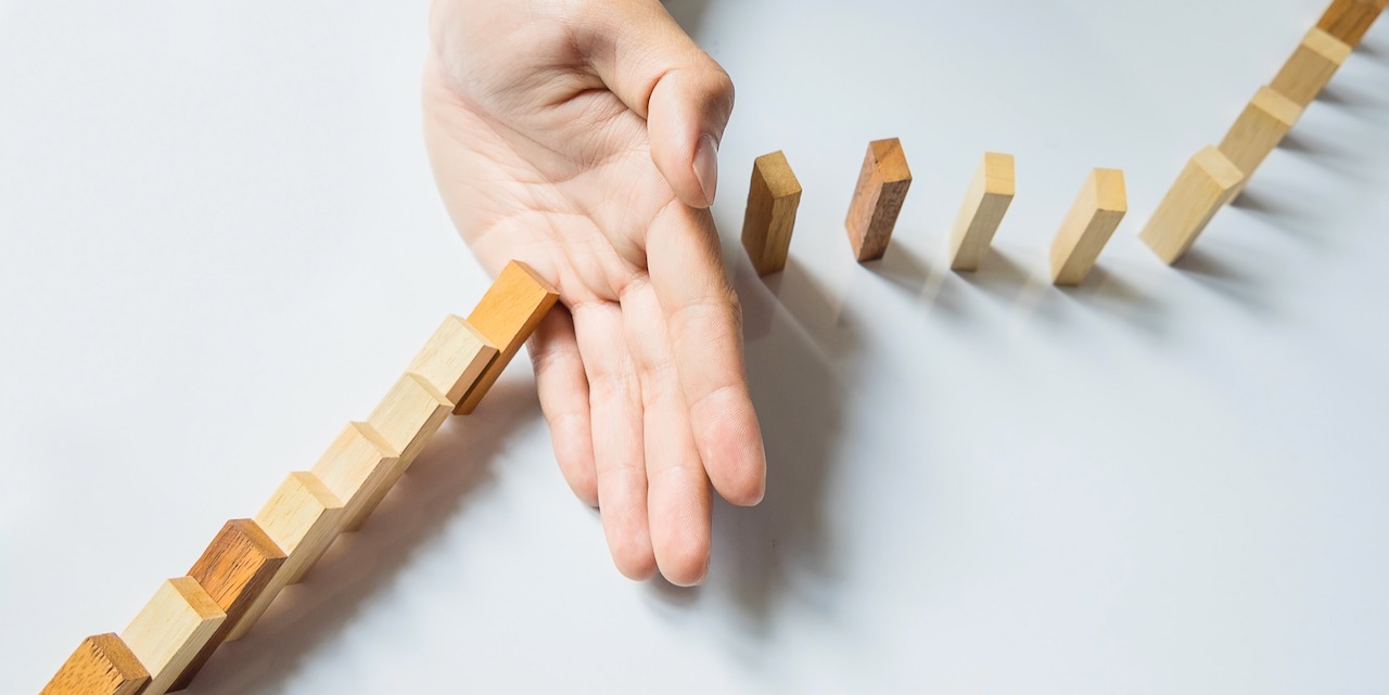 businessman hand stop dominoes continuous toppled or risk with copyspace